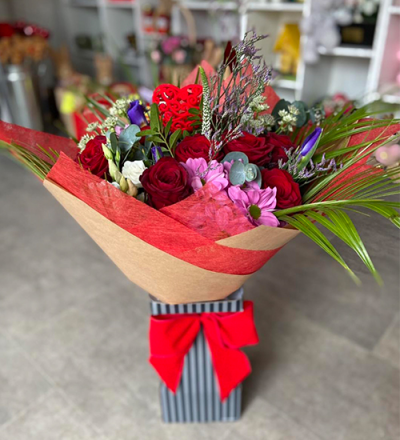 Head Over Heels - A gorgeous handtied in water presented in a gift box. To include flowers in pink, purple, red with complimentary foliage.