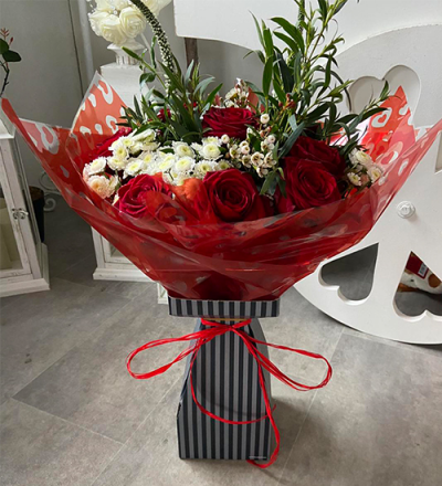 Make Them Wink - A stunning handtied in water presented in a gift box. To include flowers in red and white with complimentary foliage.