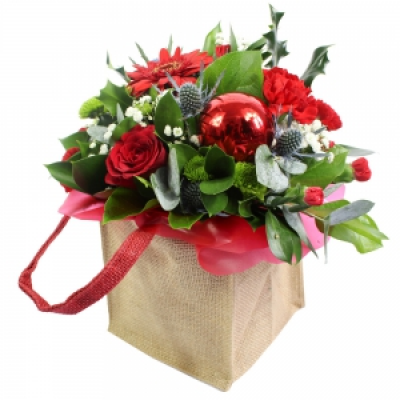 Seasons Greetings - A unique Christmas gift bag, professionally arranged and delivered by a local florist. This beautiful baubled gift will include a festive range of florist fresh flowers. Including Santini, Holly, Eucalyptus Cinnerea and Ruskus. Flowers will be hand delivered by the local florist. 
